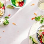 Top-down view of vibrant vegan bowls filled with fresh vegetables, perfect for a healthy meal.
