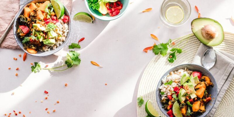 Top-down view of vibrant vegan bowls filled with fresh vegetables, perfect for a healthy meal.